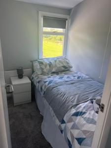 ein kleines Schlafzimmer mit einem Bett und einem Fenster in der Unterkunft Hideaway21 in Maghera + 11 Fotos