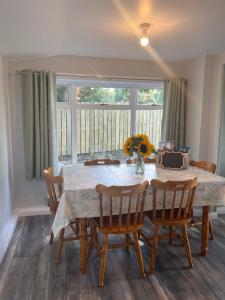 ein Esstisch mit Stühlen und einer Vase mit Blumen in der Unterkunft Hideaway21 in Maghera