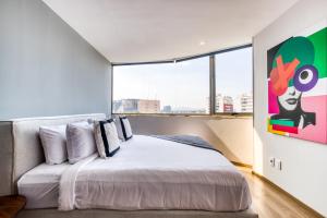 Un dormitorio con una cama grande y una ventana grande. en ULIV Apartments Polanco, en Ciudad de México