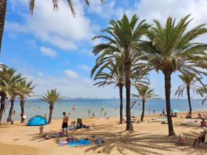 people on a beach with palm trees and the ocean at La Manga Beach House in La Manga del Mar Menor +14 photos