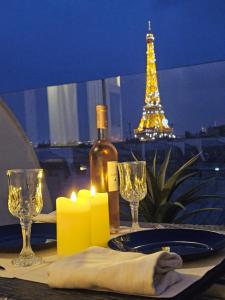un tavolo con una bottiglia di vino, candele e la torre eiffel di Pépite Tour Eiffel a Parigi