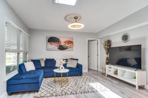 a living room with a blue couch and a tv at Updated Seminole Home with Pool - 7 Mi to Beach! in Seminole