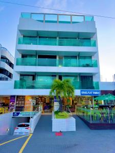 ein Gebäude mit einer Palme davor in der Unterkunft Israel Flat beira-mar in João Pessoa