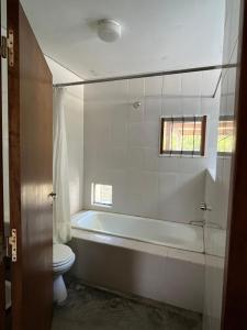 a bathroom with a bath tub and a toilet at Casa Pessoa in Pinamar