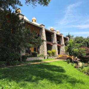 une vue extérieure d'un bâtiment avec une cour dans l'établissement Hacienda La Skondida Hotel Resort, à San Mateo Xoloc