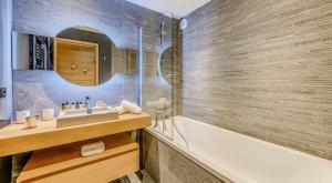 a bathroom with a tub and a sink and a mirror at Résidence Phoenix - 5 pièces 8 personnes 4 MAE-9511 in Tignes +24 photos