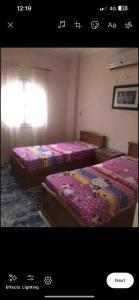 zwei Betten nebeneinander in einem Zimmer in der Unterkunft Happy home in Hurghada