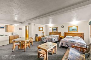 a hotel room with two beds and a table at Willamette Pass Inn & Chalets in Odell Lake