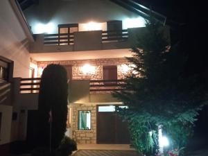 a woman standing in front of a house at night at Petra in Livno