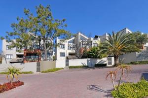 a large white building with palm trees in front of it at Sandton - Japandi style 1 bedroom Loft apartment in Sandton