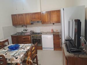 a kitchen with wooden cabinets and a table with a tableablish at Casa di Annamaria e Silvia in Marina di Pisa