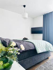 a bedroom with a bed and a table with flowers at City Center Apartments Düsseldorf in Düsseldorf