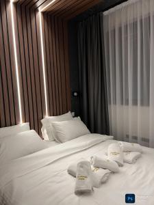 two beds with white pillows and towels on them at Helikon Zlatibor Apartman 310 in Palisad