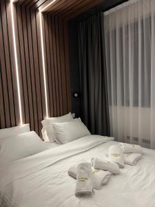 two beds with white sheets and towels on them at Helikon Zlatibor Apartman 310 in Palisad +15 photos