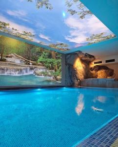 a swimming pool with a waterfall mural on the wall at Helikon Zlatibor Apartman 310 in Palisad
