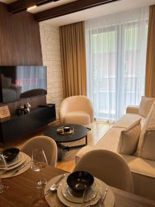 a living room with a couch and a table and chairs at Helikon Zlatibor Apartman 310 in Palisad