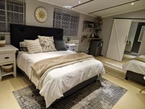 北阿利瓦尔Toekoms Inn的卧室里有一张床，墙上挂着一个钟