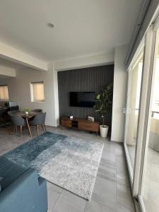 a living room with a couch and a tv on a wall at Departamento con vista al mar en Cabo Marino in Conchal