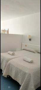 a bedroom with two beds with white sheets at BH Cura marina 2 in Mogán +25 photos