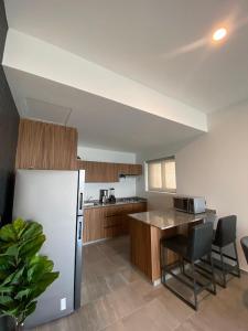 a kitchen with a refrigerator and a table and chairs at Departamento con vista al mar en Cabo Marino in Conchal