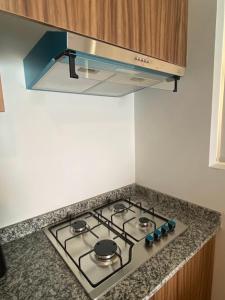 a stove top in a kitchen with a hood at Departamento con vista al mar en Cabo Marino in Conchal +18 photos