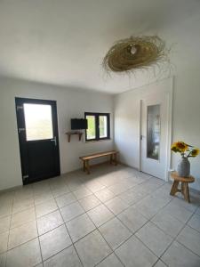una stanza con una porta nera, una panca e un tavolo di Maison au bord du lac de saint Ciergues a Perrancey