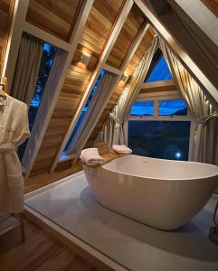 a large bath tub in a room with windows at Cabana Snowflake Urubici in Urubici +23 photos