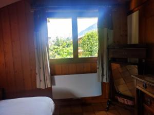a bedroom with a bed and a window with a view at TellaHouse in Chamonix