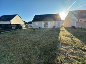 Una casa en un patio con el sol detrás. en Domaine des roses - Charmante Maison à Louer, en Sonzay