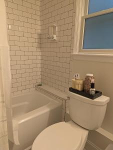 e bagno con servizi igienici bianchi e vasca. di Tranquil Getaway Cottage in Charming, Bethel CT a Bethel