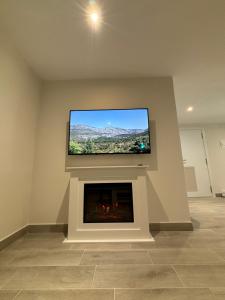 a living room with a flat screen tv above a fireplace at Camiño da Camposa in Muxia