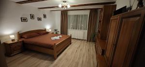 a bedroom with a bed and a television in it at Casa Ramo in Râşnov