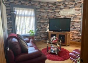 a living room with a couch and a flat screen tv at Masons Nook 292 Mansfield Road NG174HR in Skegby