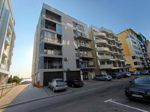 a tall building with cars parked in front of it at apartament plaja Florian in Mamaia