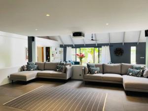 a large living room with couches and a rug at Villa Moana Reva in Bora Bora