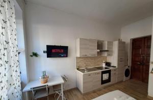 a kitchen with a sink and a tv on the wall at cosycasa & free bike in Turin