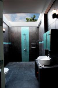 a bathroom with a shower and a toilet and a sink at Boutique Beach All Inclusive Diving Hotel in Dhigurah