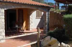 ein Steingebäude mit einer Terrasse mit einem Tisch in der Unterkunft Agriturismo La Sede Di Carlo in Saturnia