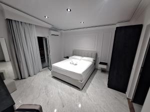 una camera da letto con un letto bianco e una finestra di Bar Restorant Hotel Rama a Belsh
