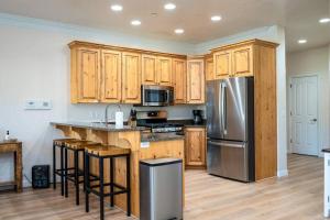 una cucina con mobili in legno e un frigorifero in acciaio inossidabile di Snowbasin Lakehouse with Hot Tub and Resort Amenities a Huntsville