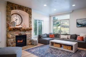un soggiorno con divano e camino di Snowbasin Lakehouse with Hot Tub and Resort Amenities a Huntsville