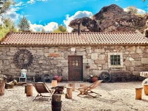 a stone house with rocking chairs in front of it at Moinho de Brião in Montalegre
