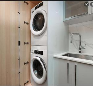 una cocina con 2 lavadoras y un fregadero en one bedroom, en Victoria