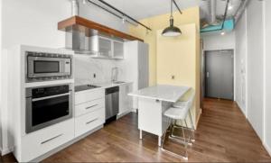 Una cocina con gabinetes blancos y encimera. en one bedroom, en Victoria