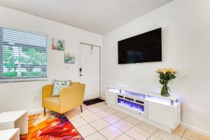 a living room with a tv and a yellow chair at 2 Mi to Dtwn Hollywood Vibrant Pet-Friendly Condo in Hallandale Beach