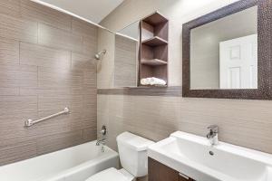 a bathroom with a sink and a toilet and a mirror at 2 Mi to Dtwn Hollywood Vibrant Pet-Friendly Condo in Hallandale Beach +16 photos