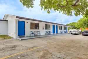 a building with blue doors and chairs in a parking lot at 2 Mi to Dtwn Hollywood Vibrant Pet-Friendly Condo in Hallandale Beach