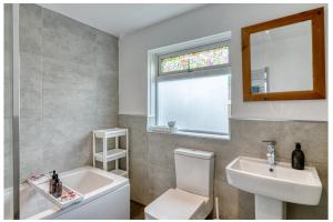 a bathroom with a sink and a toilet and a window at Full House, Massage Mattresses, Sleeps 6 guests, Free wifi, Free Parking, Free Netflix, Smart TV in Manchester +17 photos