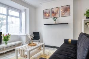 a living room with a couch and a table at Full House, Massage Mattresses, Sleeps 6 guests, Free wifi, Free Parking, Free Netflix, Smart TV in Manchester