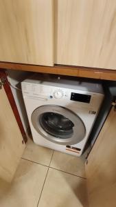 a washing machine in a kitchen under a cabinet at Central plaja Neversea in Constanţa
